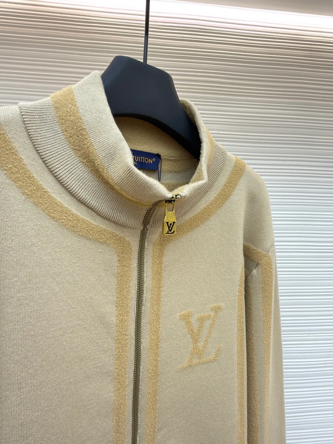 LOUIS VUITTON two-color splicing intarsia zipper jacket ●Original version: purchased and developed at 20700 ●Item number: 1681968-C15 ●Fabric: nylon fabric ●Technology: intarsia production ●Color: khaki ●Version: fitted version ●Weight: about 1020 grams ●Size: XS-S-M-L ●Description: Made of 43% nylon, 32% cotton and 25% viscose blended fabric, which has both comfort and stiffness. The designer used two-tone intarsia technology to allow contrasting color strips to run through the sleeves and body, forming a smooth visual extension. Different areas create subtle three-dimensional texture effects by changing knitting density and stitching methods. The chest is decorated with a delicate intarsia LV logo, and the Vuitton word is presented in elegant font on the back, showing brand recognition in every detail. The collar, cuffs and hem made of rib knitting technology not only enhance the stability of the silhouette, but also echo the overall design language. The front placket features a smooth zipper closure and practical slip pockets on both sides for added functionality. The entire piece perfectly interprets the exquisite aesthetics of sports and leisure style through the ingenious combination of fabric texture and craftsmanship details. The overall wiring is straight and delicate, the fabric is comfortable and soft, and the color is consistent without color difference. It can be matched with the same style to create a fashionable look and control various occasions. Customized accessories, complete with three standards, same style for men and women!